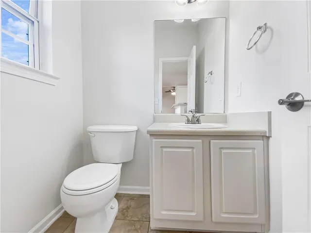 a bathroom with a granite countertop toilet sink and mirror