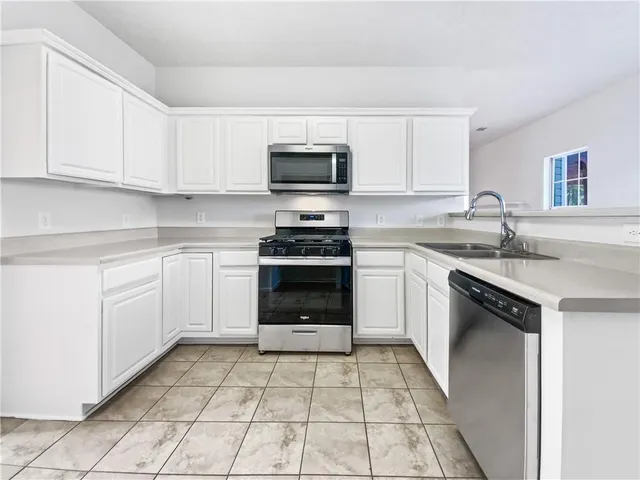 a kitchen with a sink stove and cabinets