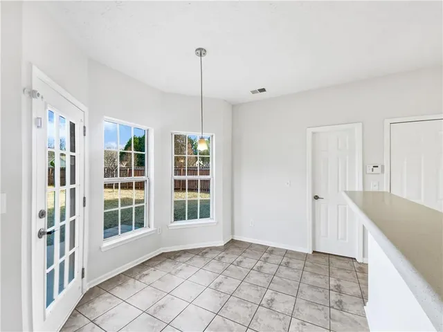 a view of an empty room with window and cabinet