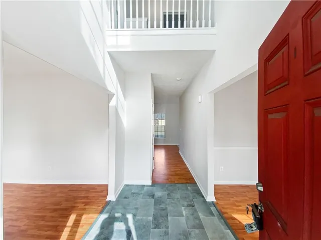a view of a hallway with wooden floor and a bathroom view