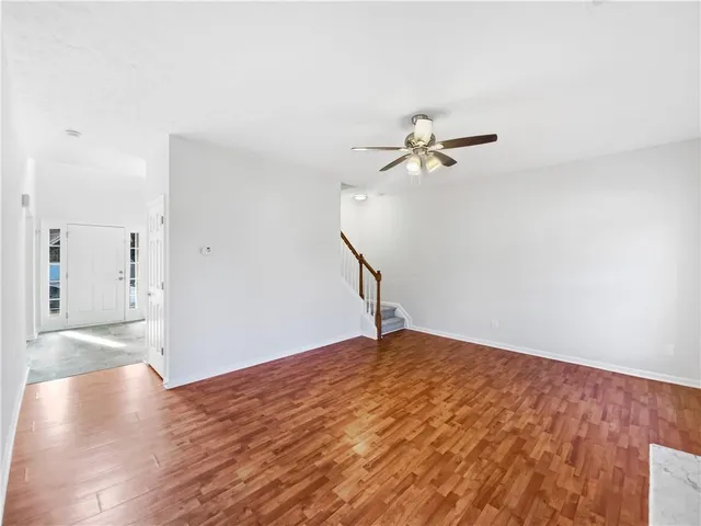a view of a room with wooden floor and a ceiling fan