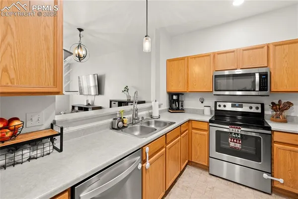 a kitchen with stainless steel appliances a stove a sink and white cabinets