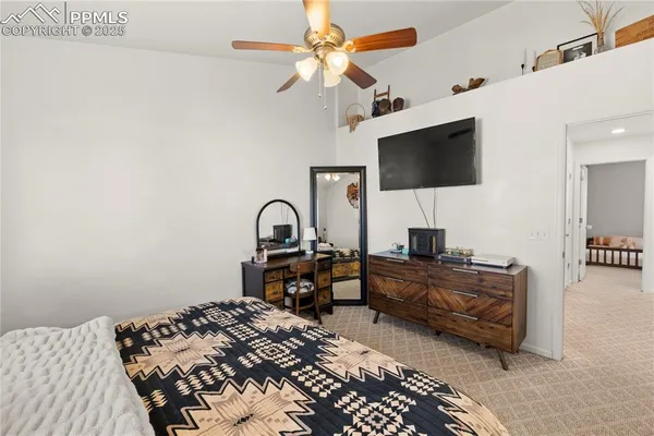 a bedroom with bed tv and a chandelier