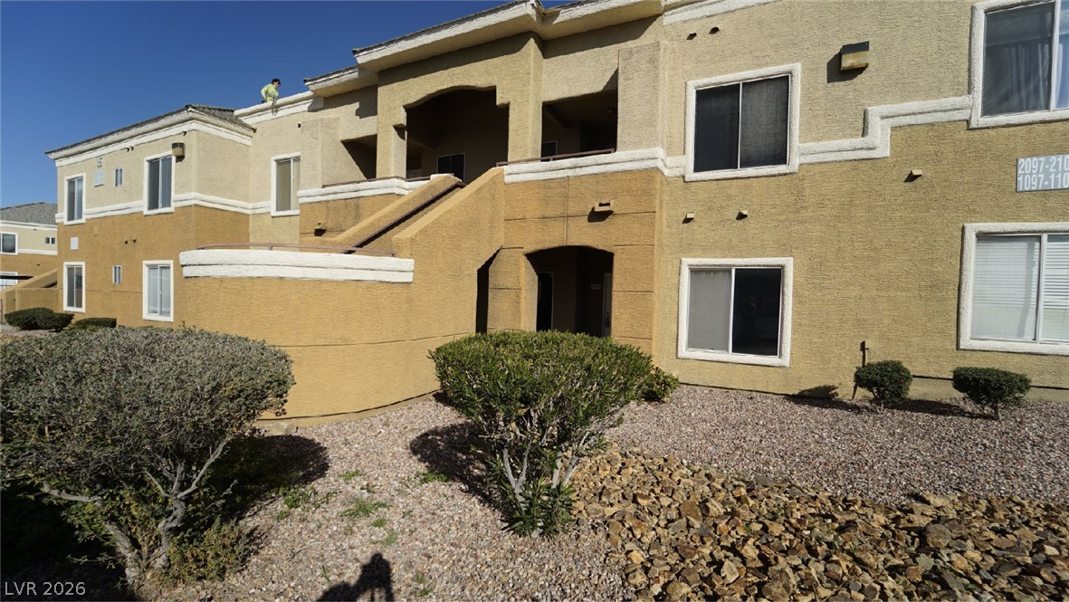 8070 West Russell Road, Unit 1099 Las Vegas, NV 89113 - Photo 4 of 31 Multi-level residential building with stucco finish and a striking exterior staircase.