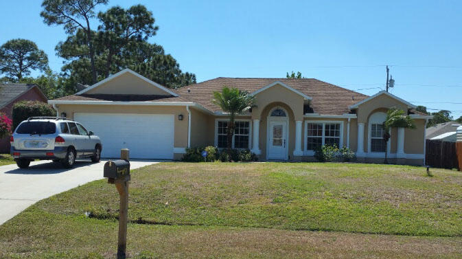 174 Southwest Sea Lion Road Port St. Lucie, FL 34953 - Photo 1 of 31 a front view of a house with a yard