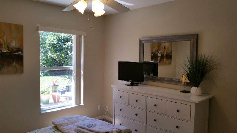 174 Southwest Sea Lion Road Port St. Lucie, FL 34953 - Photo 23 of 31 a living room with furniture and a flat screen tv