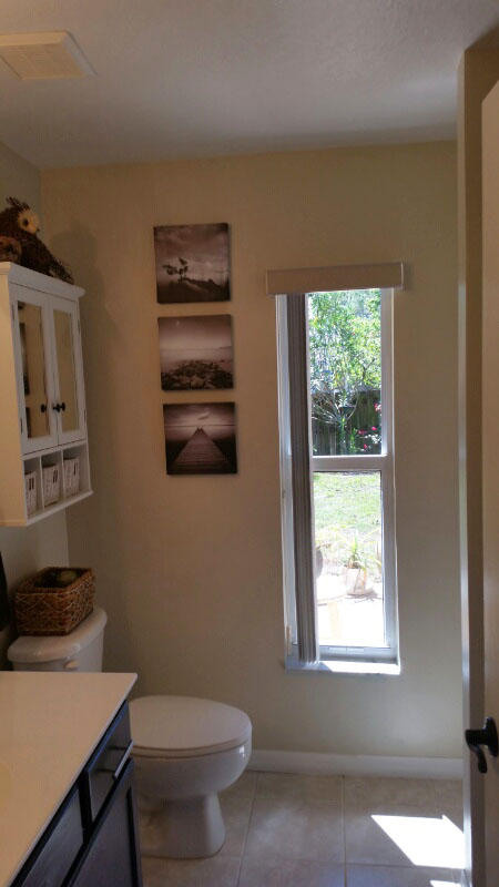 174 Southwest Sea Lion Road Port St. Lucie, FL 34953 - Photo 24 of 31 a bathroom with a toilet a sink and a window