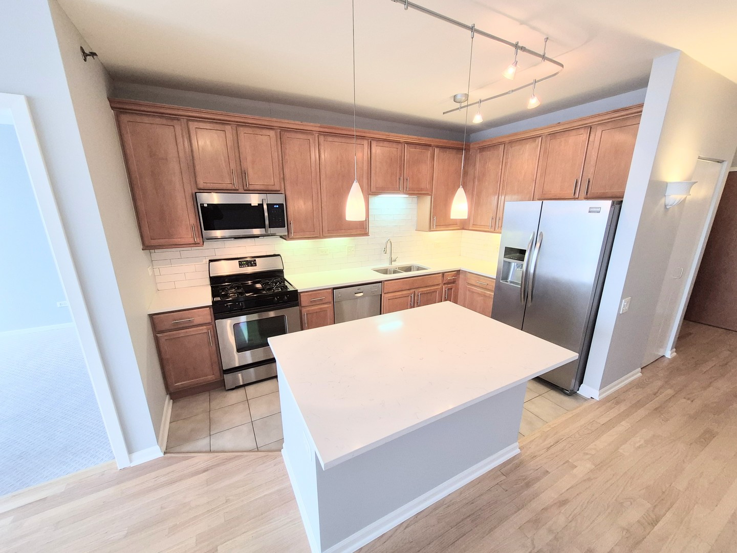 210 South Desplaines Street, Unit 707 Chicago, IL 60661 - Photo 4 of 21 a large kitchen with stainless steel appliances a stove a refrigerator a sink a dining table and chairs