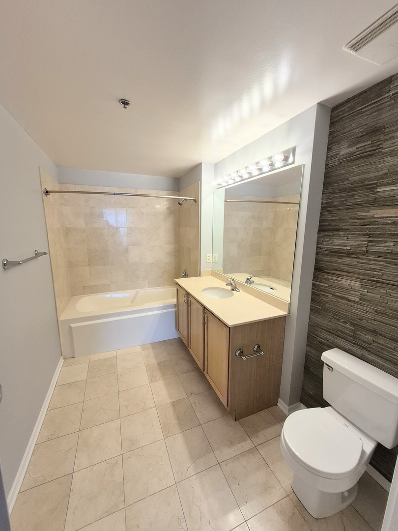 210 South Desplaines Street, Unit 707 Chicago, IL 60661 - Photo 6 of 21 a bathroom with a sink mirror vanity and toilet