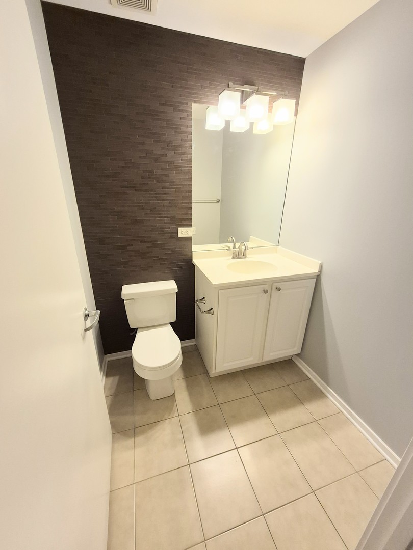 210 South Desplaines Street, Unit 707 Chicago, IL 60661 - Photo 7 of 21 a bathroom with a toilet sink and mirror