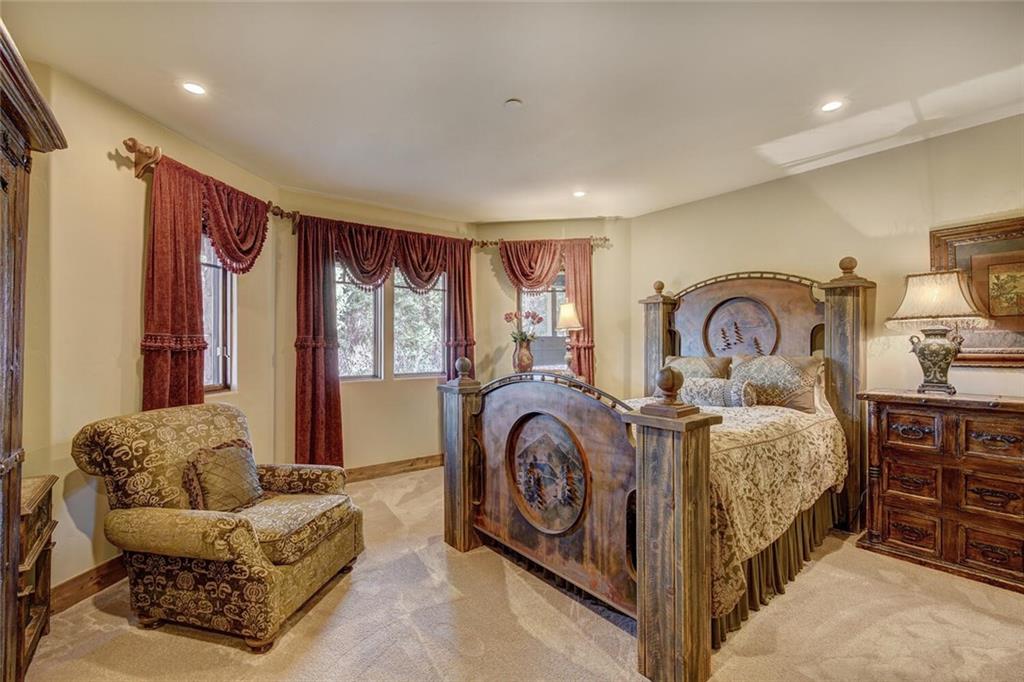 1065 4 O Clock Road Breckenridge, CO 80424 - Photo 20 of 35 a spacious bedroom with a bed a couch and dresser