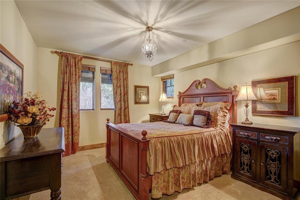 1065 4 O Clock Road Breckenridge, CO 80424 - Photo 21 of 35 a bedroom with a bed and a chandelier
