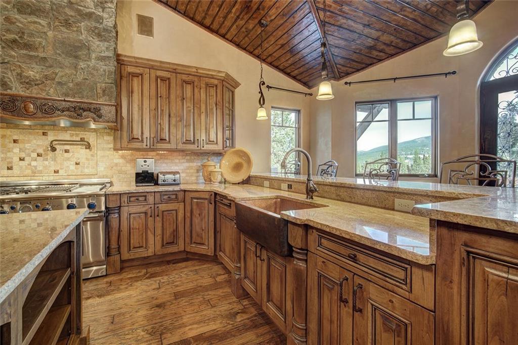 1065 4 O Clock Road Breckenridge, CO 80424 - Photo 24 of 35 a kitchen with stainless steel appliances granite countertop a sink a stove and a wooden floors