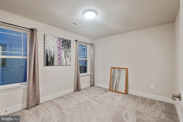 an empty room with closet and windows