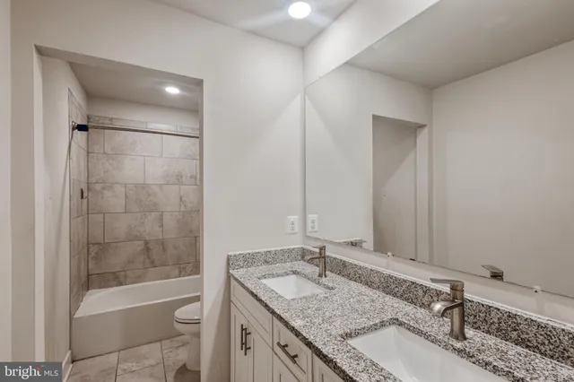 a bathroom with a granite countertop sink mirror toilet and bathtub