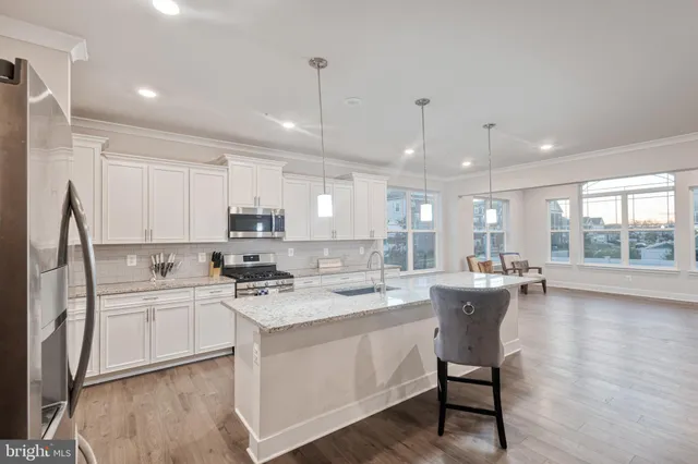a kitchen with a sink a counter top space stainless steel appliances and a window
