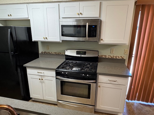 3603 Buffalo Springs Trail, Unit B Georgetown, TX 78628 - Photo 14 of 16 a kitchen with stainless steel appliances wooden cabinets and a stove top oven
