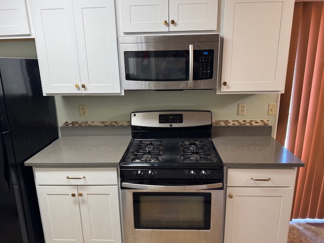 3603 Buffalo Springs Trail, Unit B Georgetown, TX 78628 - Photo 15 of 16 a kitchen with stainless steel appliances granite countertop white cabinets and black stove top oven