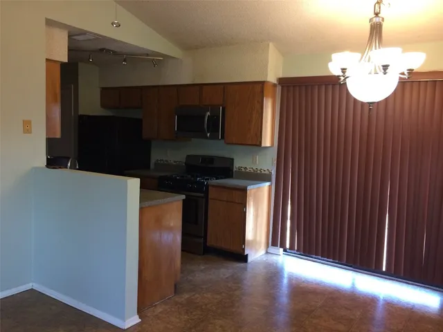 a kitchen with stainless steel appliances granite countertop a refrigerator and a stove top oven