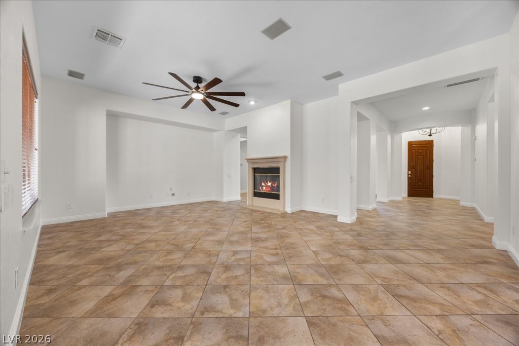 2125 De Rouge Avenue Henderson, NV 89044 - Photo 37 of 96 A spacious, airy living space features a cozy fireplace and attractive tile flooring.