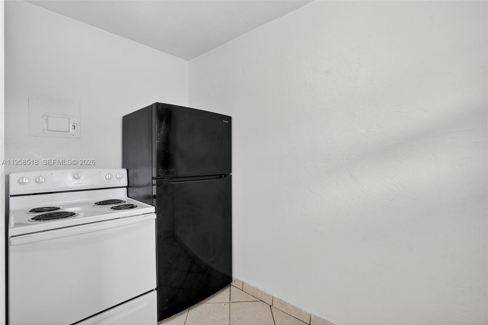 1716 Northwest 19th Street Miami, FL 33125 - Photo 8 of 20 a view of a refrigerator in kitchen and white cabinets