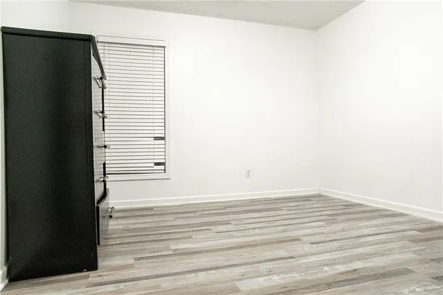 a view of a bedroom with wooden floor