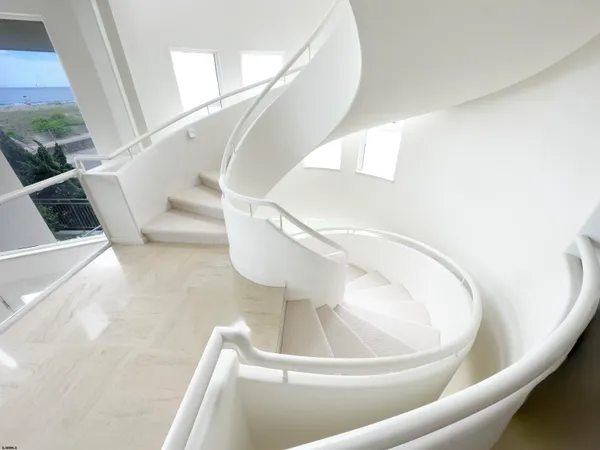 a living room with stainless steel appliances furniture and a kitchen view