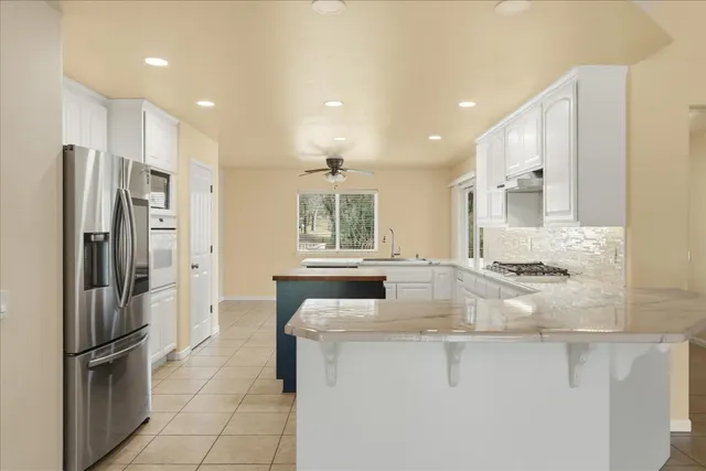 a kitchen with stainless steel appliances granite countertop a sink and a stove