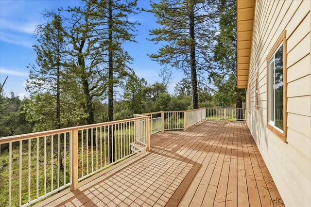 a view of balcony with wooden floor and fence