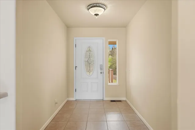 a view of an empty room with wooden floor and a fireplace