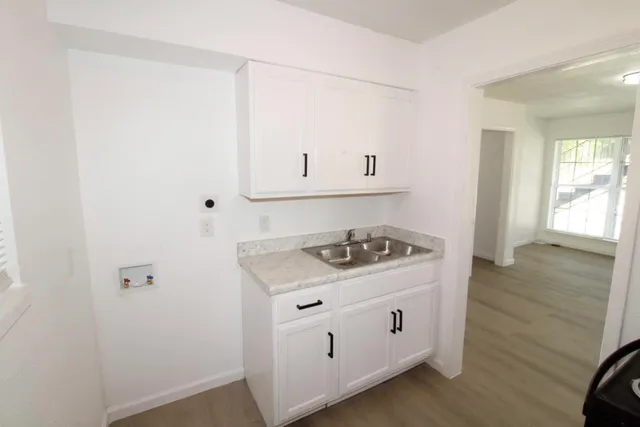 a kitchen with cabinets stove and sink
