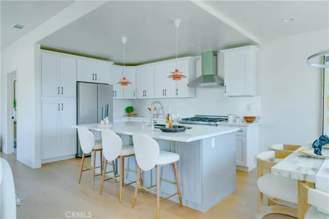 a kitchen with a sink a stove a refrigerator and white cabinets