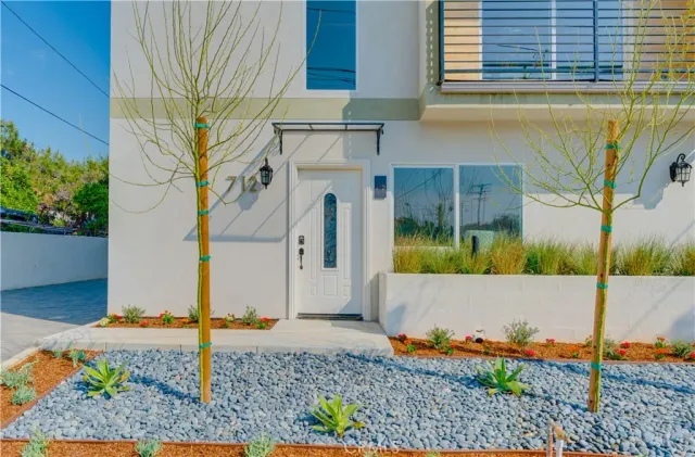 a view of a brick house with a small yard and sitting area