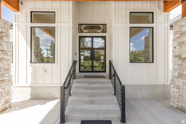 1188 South Old Trappers Loop Road Huntsville, UT 84317 - Photo 17 of 92 Modern entry featuring board and batten siding, stone veneer accents, and a wood beam overhang