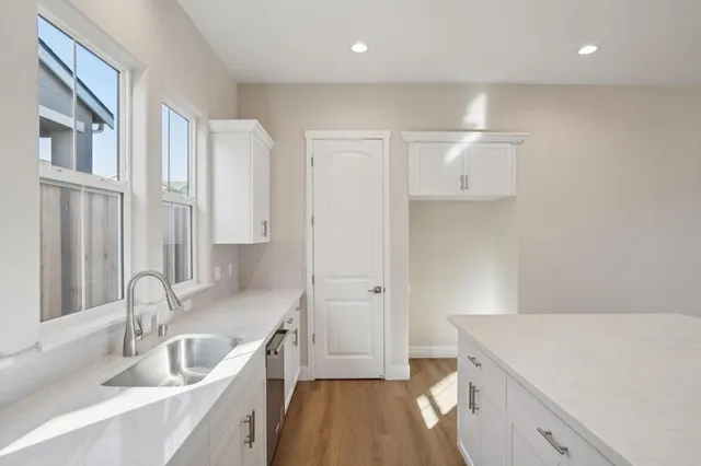 a kitchen with granite countertop a stove and a white cabinets
