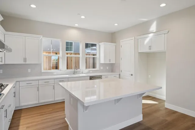 a large kitchen with cabinets wooden floor and stainless steel appliances