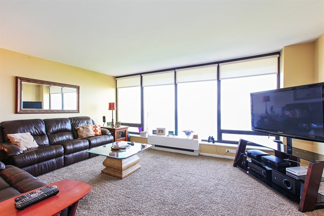 5445 North Sheridan Road, Unit 3904 Chicago, IL 60640 - Photo 2 of 8 a living room with furniture and a floor to ceiling window