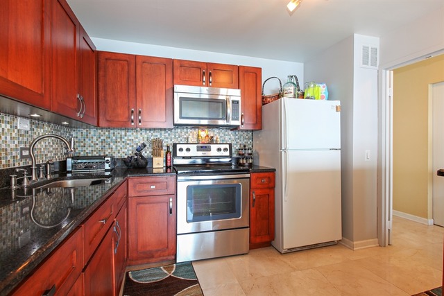 5445 North Sheridan Road, Unit 3904 Chicago, IL 60640 - Photo 3 of 8 a kitchen with stainless steel appliances granite countertop a refrigerator a stove top oven a sink and dishwasher