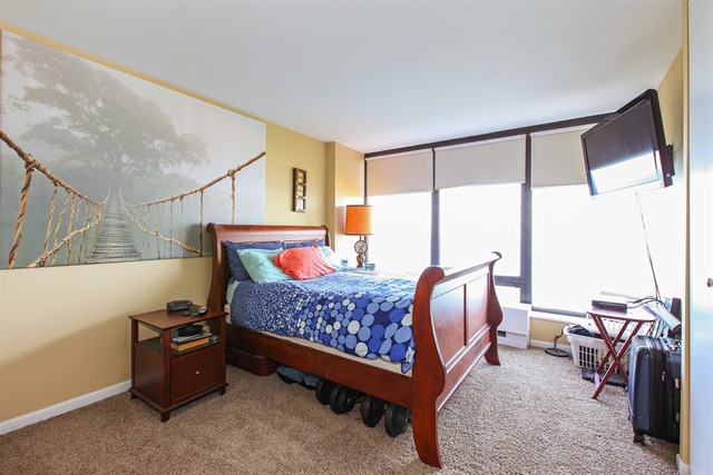5445 North Sheridan Road, Unit 3904 Chicago, IL 60640 - Photo 6 of 8 a bed room with a bed and a chair