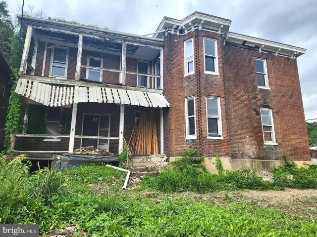 front view of a brick house with large windows and a yard