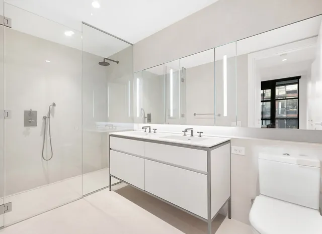 a bedroom with a large bed and a potted plant