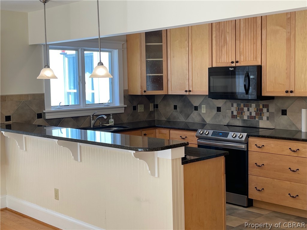 931 Laurel Point Road Lancaster, VA 22503 - Photo 7 of 21 a kitchen with stainless steel appliances granite countertop a sink a stove and a microwave