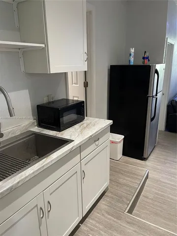 a kitchen with a refrigerator and a sink