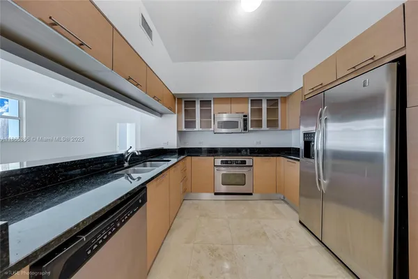 a large kitchen with granite countertop a refrigerator a stove and a sink