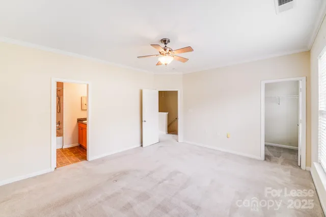 an empty room with windows and ceiling fan