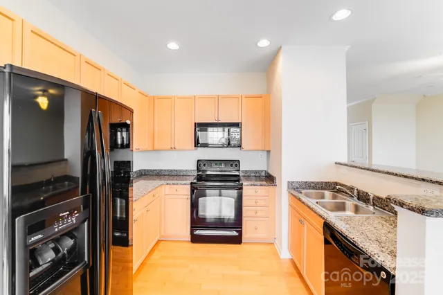 a kitchen with stainless steel appliances granite countertop a stove a sink and a refrigerator