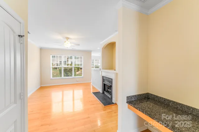 a view of an empty room with a fireplace and a window