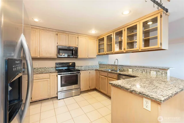 a kitchen with granite countertop a stove a sink and a microwave
