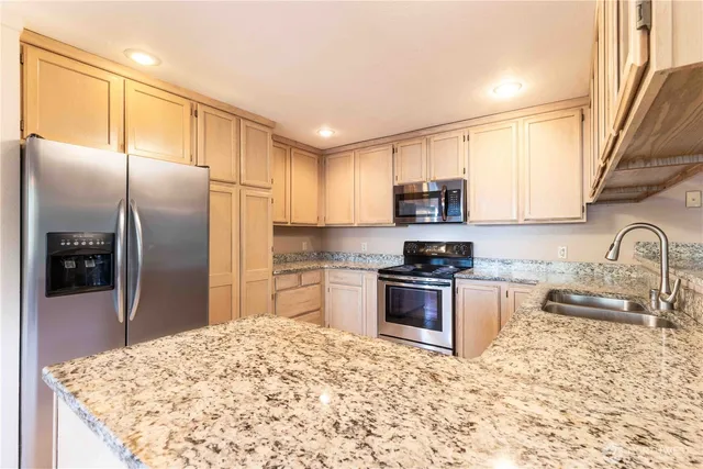 a kitchen with granite countertop a refrigerator and a sink