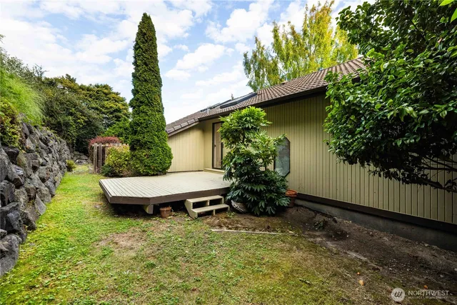 a view of a backyard with plants and a bench